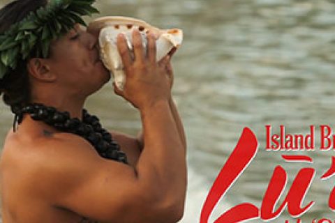 A cultural Polynesian man wearing a leaf crown and traditional necklace, drinking from a conch shell.